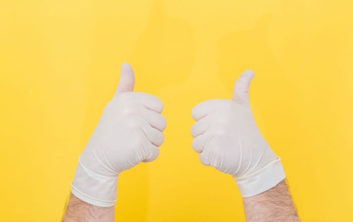two hands in gloves giving thumbs up