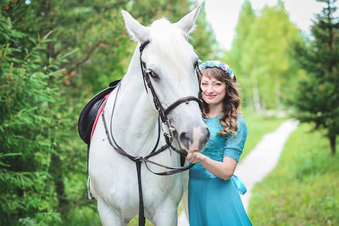 woman standing by white horse